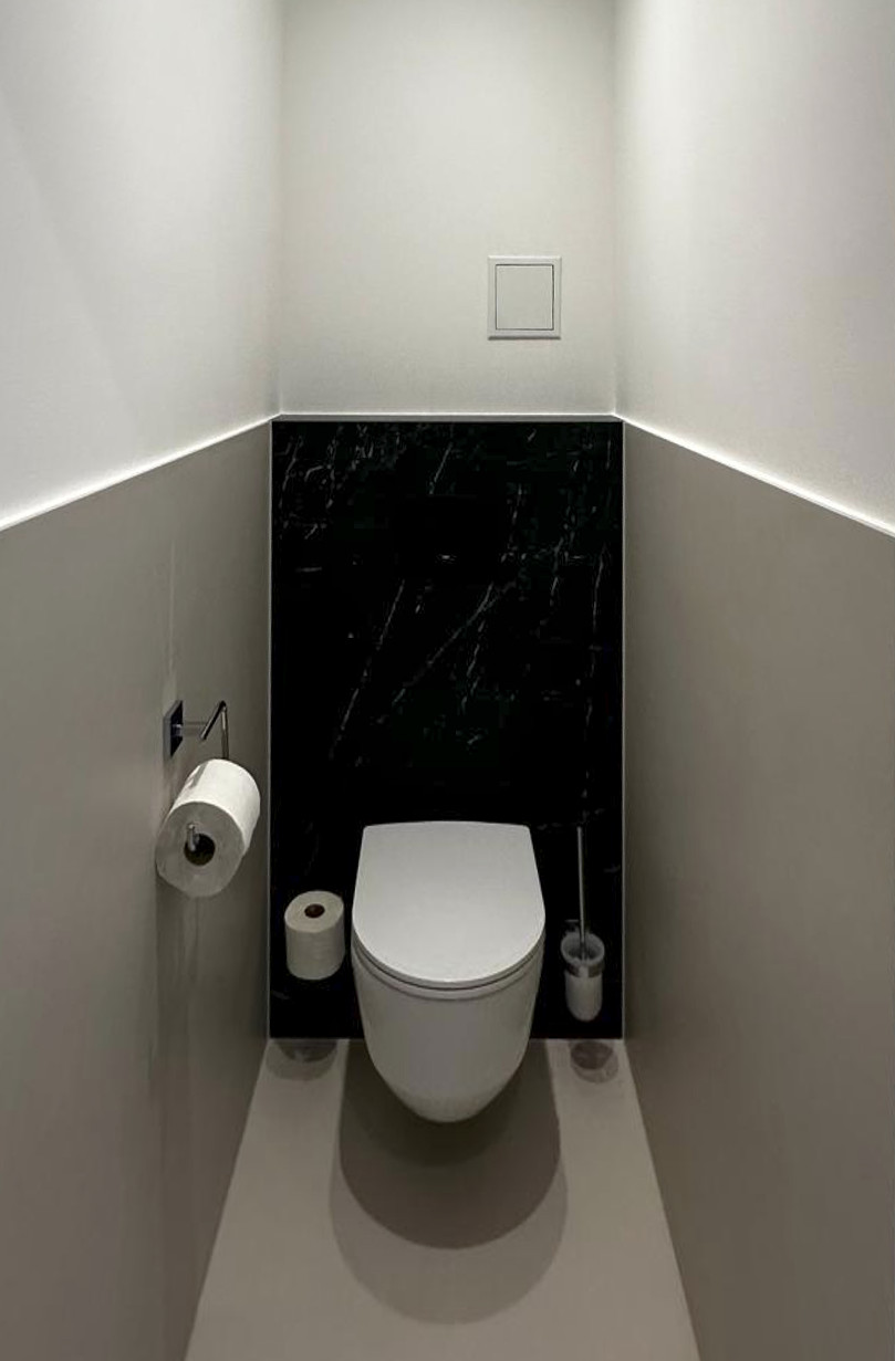 Separates WC mit Dekton-Feinsteinzeug und indirekter Beleuchtung