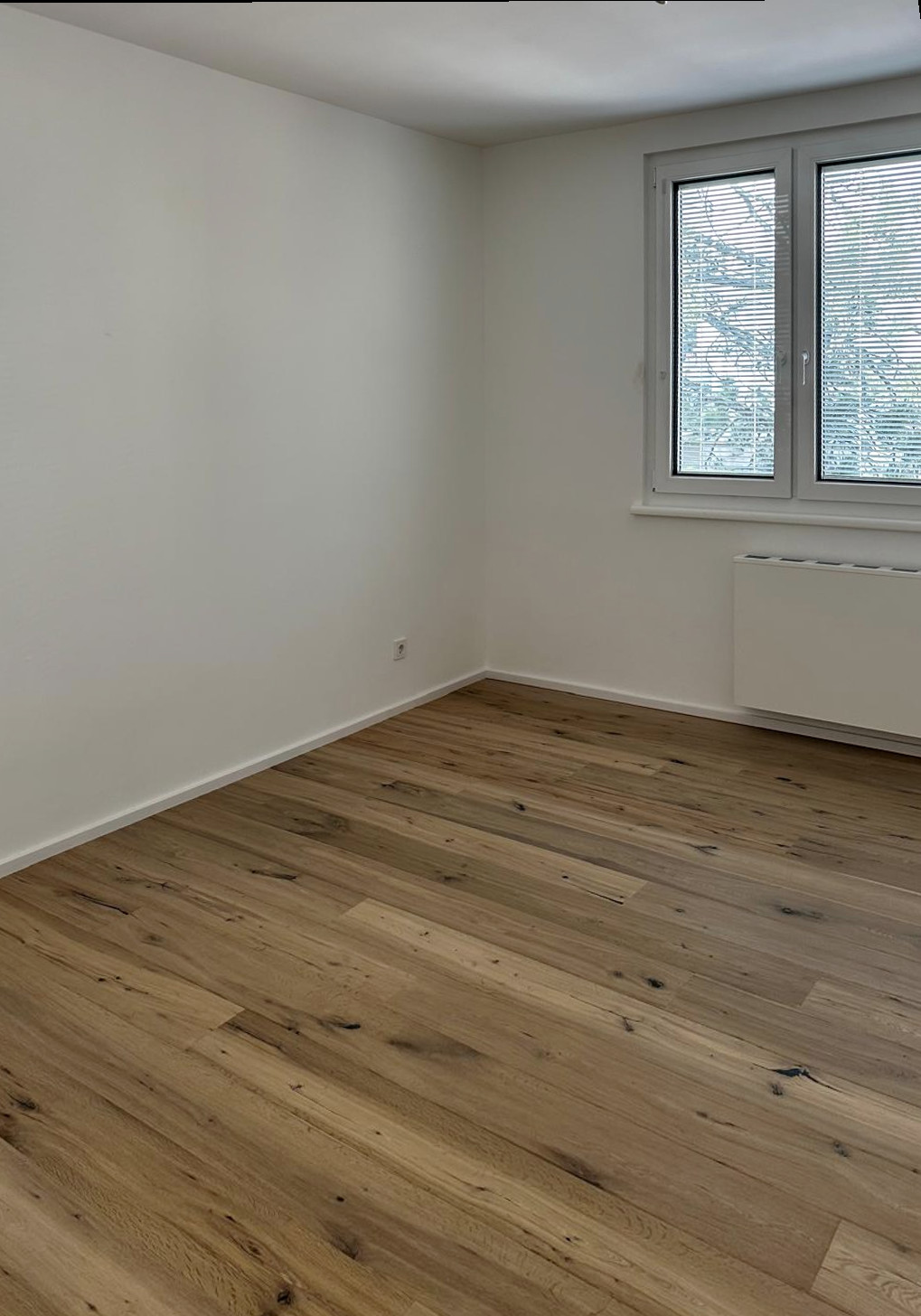 Helles Wohnzimmer mit Eichenparkett und Blick ins Grüne