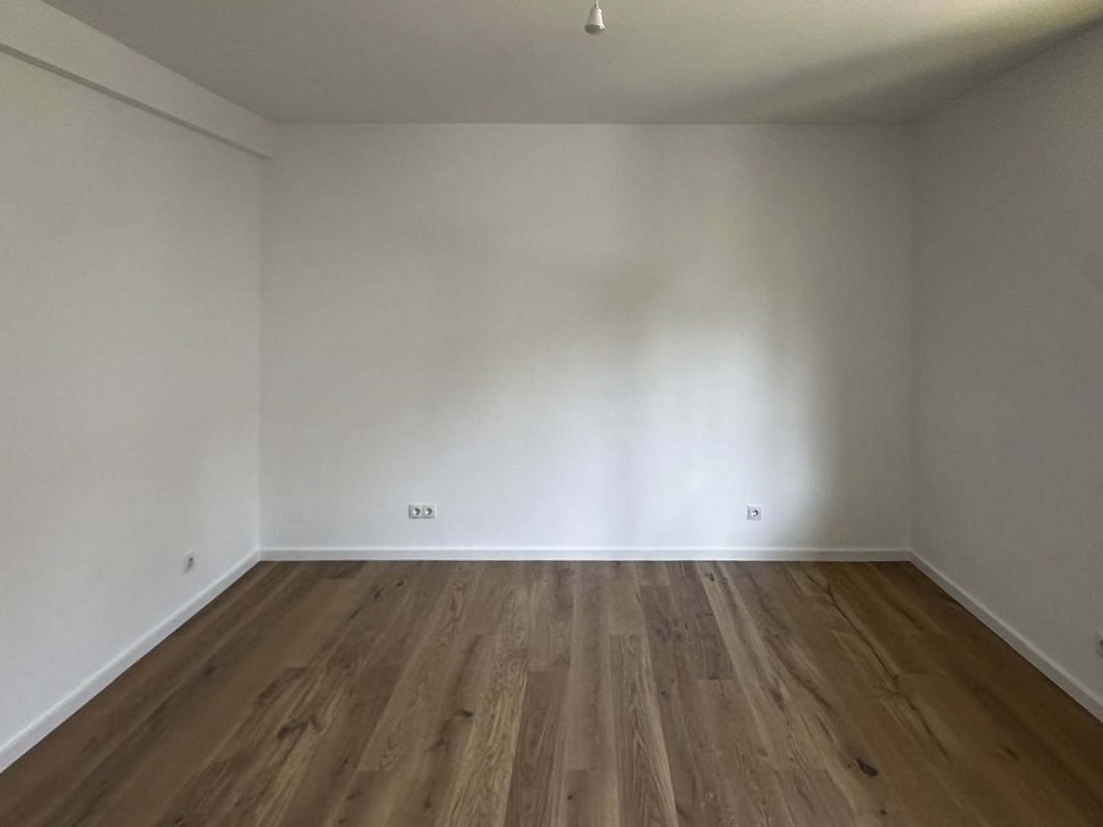 Helles Zimmer mit Weitzer Holzdielenboden und Blick ins Grüne